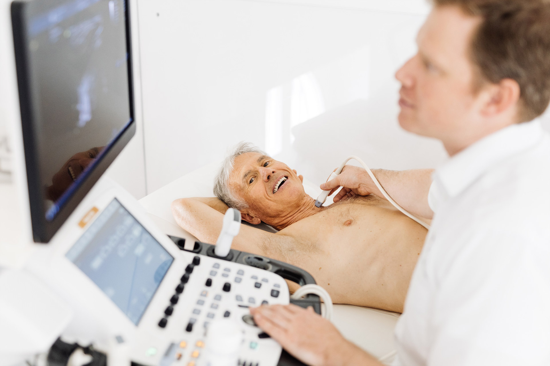 Patient und Arzt bei einer Ultraschall-Untersuchung am Hals